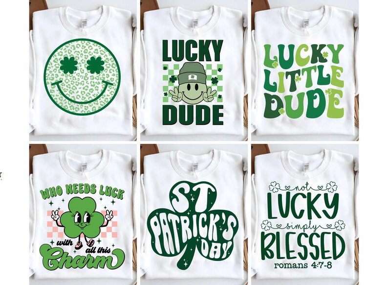 May include: Six white t-shirts with green shamrock and St. Patrick's Day themed designs. The designs include a smiling shamrock, the text "Lucky Dude", "Lucky Little Dude", "Who Needs Luck with All This Charm", "St. Patrick's Day", and "Not Lucky Simply Blessed Romans 4:7-8".