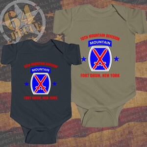 May include: Two baby onesies, one navy blue and one olive green, each featuring the text "10th Mountain Division MOUNTAIN FORT DRUM, NEW YORK." The design includes a blue shield with crossed red swords and blue stars.
