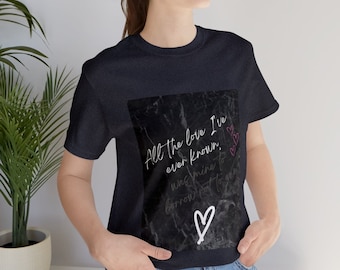 May include: A navy blue t-shirt with a black and white marble design. The design features the text "All the love I've ever known was mine to borrow not to own" with a white heart.