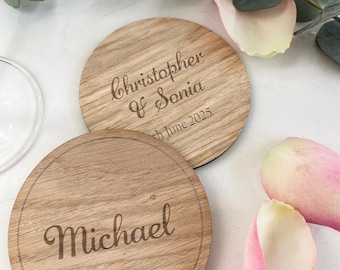 Könnte beinhalten: Zwei runde Untersetzer aus Holz mit graviertem Text. Auf einem Untersetzer steht "Christopher & Sonia, 8. Juni 2025". Auf dem anderen Untersetzer steht "Michael". Die Untersetzer sind hellbraun und haben eine natürliche Holzmaserung.