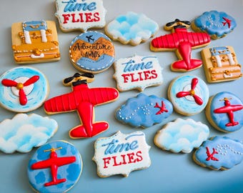 Advanture awaits airplane clouds time flies anniversary baby shower reveal  it's  a boy girl blue red  pastel colors suitcase  cookies