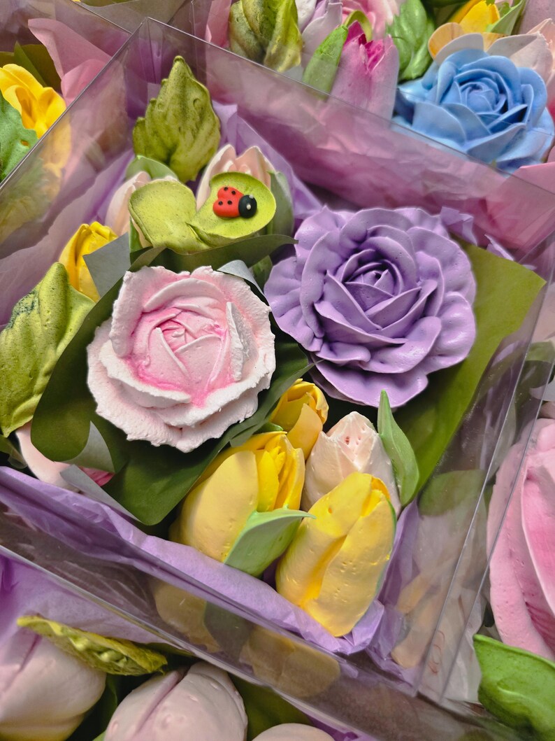 May include: Close-up of colorful floral arrangements featuring pastel-colored roses, tulips, and other flowers. The bouquets are wrapped in purple tissue paper and clear plastic. A small ladybug decoration is visible on one of the leaves.