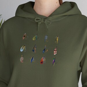 May include: A green hooded sweatshirt with a pattern of colorful fishing flies printed on the front.