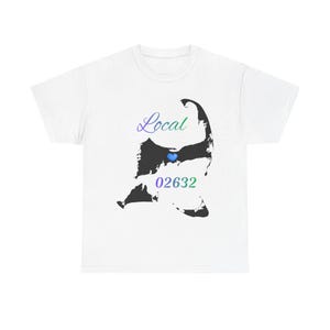 May include: White t-shirt with a black landmass silhouette, a blue heart, and the text "Local 02632" in green and purple. A casual wear item.