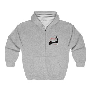 May include: A light gray zip-up hoodie featuring a black and white graphic of a coastal outline with the word "Local" in red script. The hoodie has a hood and a full-length zipper.
