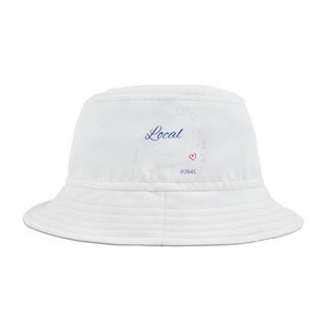 Pode incluir: Um chapéu de pescador branco com um contorno azul do estado de Massachusetts e a palavra "Local" em escrita azul. O contorno inclui um coração vermelho e o número "02645" em preto.