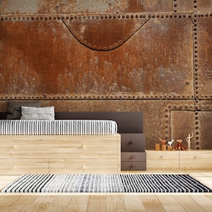 Può includere: Un interno di una camera da letto con un murale murale in metallo rustico, una struttura del letto in legno con una trapunta a righe, un'unità di scaffalatura in legno, uno sgabello nero e un tappeto con un motivo a righe bianche e nere.