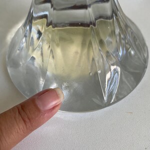 May include: Clear glass vase with a flared base and a textured, ridged design. The vase has a wide, circular base and a slender neck, ideal for displaying flowers or as a decorative piece.