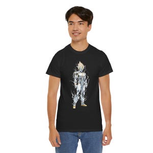 May include: Black t-shirt featuring a full-body illustration of a character in a white and silver armored suit with spiky blonde hair. The character is surrounded by white lightning bolts. The shirt is made of a soft material.