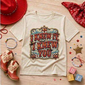 Retro western-style typography design featuring the phrase “I Knew It, I Knew You” in bold vintage red and orange lettering with blue shadows. The artwork includes cowboy hats, sheriff badges, stars, clouds, rope border details, and a rustic cowboy theme, making it ideal for a 5th birthday shirt, western birthday party, family matching apparel, and print-on-demand products.