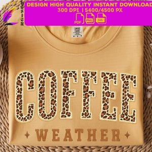 Peut inclure: T-shirt moutarde avec le mot "COFFEE" en grandes lettres à imprimé léopard. En dessous, le mot "WEATHER" est brodé en marron, en police serif. Le t-shirt est présenté sur une surface tissée.