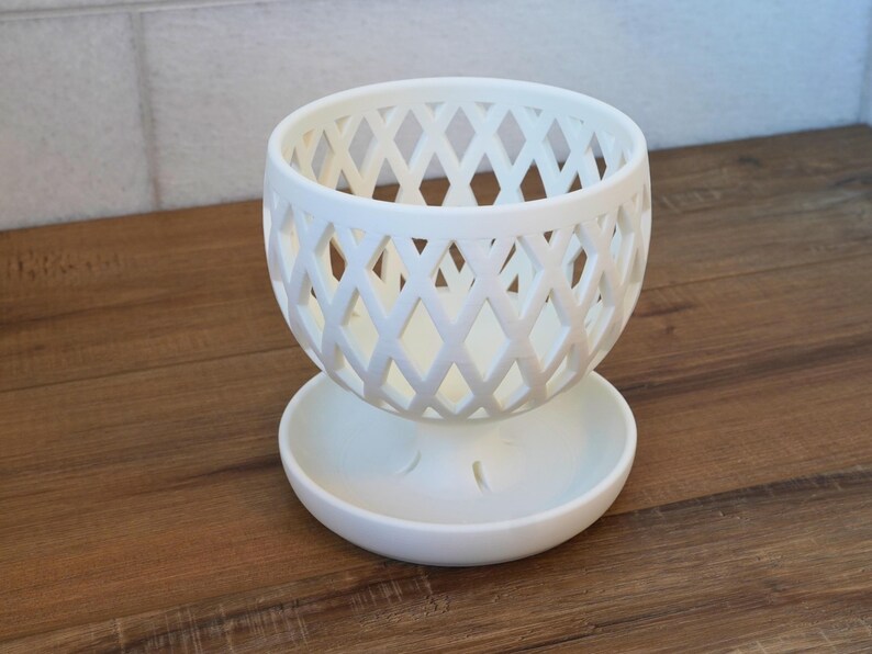 May include: White ceramic planter with a diamond-shaped lattice design. The planter has a separate saucer.