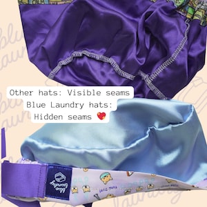 May include: Close-up of two satin hats in shades of purple and light blue. The purple hat has visible seams, while the light blue hat has hidden seams. The light blue hat has a patterned band with the text "TIMS-2UT!" and the brand "Blue Laundry".