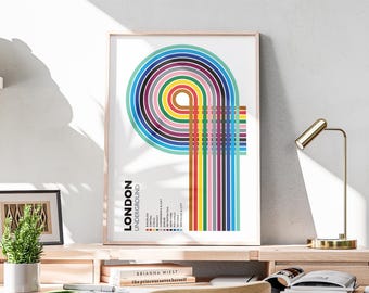 Può includere: Una stampa artistica incorniciata con un design astratto e colorato ispirato alla metropolitana di Londra. L'opera presenta cerchi concentrici e linee verticali in vari colori, con le parole "London Underground" visualizzate.