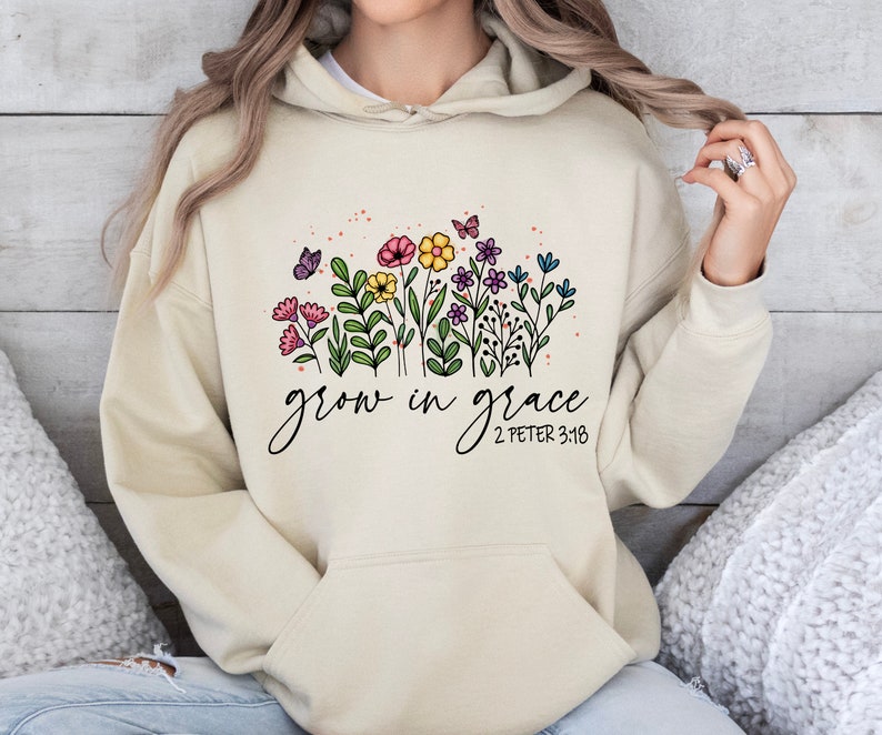 May include: A beige hoodie with a floral design and the text "grow in grace 2 Peter 3:18" printed on the front.