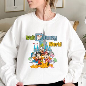 Puede incluir: Sudadera blanca con la inscripci&oacute;n "Walt Disney World" y un castillo. El dise&ntilde;o incluye a Mickey Mouse, Minnie Mouse, Donald Duck, Goofy y Daisy Duck.