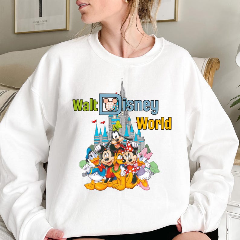 Puede incluir: Sudadera blanca con la inscripci&oacute;n "Walt Disney World" y un castillo. El dise&ntilde;o incluye a Mickey Mouse, Minnie Mouse, Donald Duck, Goofy y Daisy Duck.