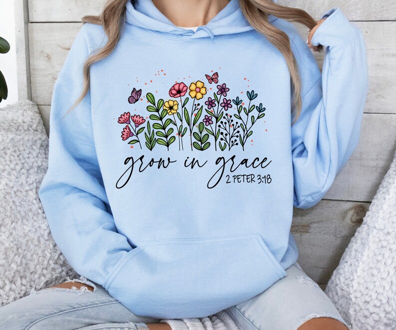 May include: Light blue hooded sweatshirt with a floral design and the text "grow in grace 2 Peter 3:18".