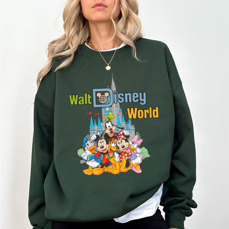 Puede incluir: Sudadera verde oscuro con el texto "Walt Disney World" y un gr&aacute;fico de personajes de Disney y el castillo de Cenicienta. La sudadera tiene cuello redondo y mangas largas. El gr&aacute;fico incluye Mickey Mouse, Donald Duck, Goofy y Minnie Mouse.