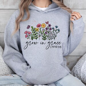 May include: Gray hooded sweatshirt with a floral design and the text "grow in grace 2 Peter 3:18".