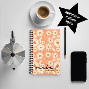 May include: A spiral bound notebook with a peach background and a white daisy pattern. The notebook says "grandma" with a heart.