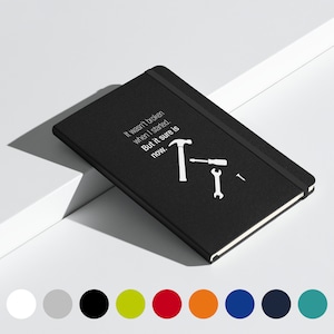 Puede incluir: Cuaderno negro con una cita blanca que dice "No estaba roto cuando empecé. Pero seguro que ahora sí." La cita está acompañada de un martillo, un destornillador, una llave y un tornillo blancos.