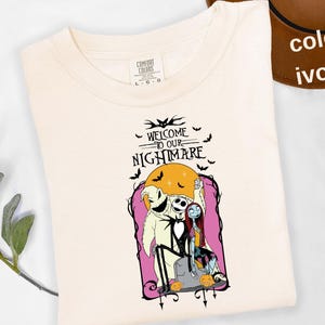 Puede incluir: Camiseta color marfil con un gr&aacute;fico de "Pesadilla antes de Navidad". El dise&ntilde;o incluye a Jack Skellington, Sally y Oogie Boogie frente a una luna llena, con el texto "WELCOME TO OUR NIGHTMARE."