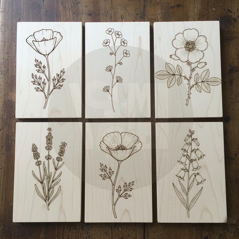 Puede incluir: Seis placas de madera con ilustraciones bot&aacute;nicas grabadas. Cada placa presenta un dise&ntilde;o floral diferente, incluyendo una amapola, delicados tallos, una rosa, lavanda, otra amapola y flores en forma de campana. Los dise&ntilde;os son de color marr&oacute;n oscuro.