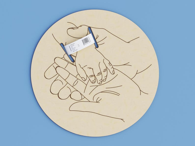 May include: A light beige wooden circle with a line drawing of hands holding a baby's hand. A blue and white hospital wristband is on the baby's wrist. The background is a solid light blue.
