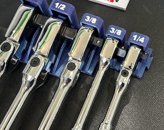 May include: A set of chrome ratchet wrenches in blue holders, labeled with sizes 1/2, 3/8, and 1/4. The wrenches are arranged in a row, with the brand name "QRT ORGANIZERS" visible on a white label.