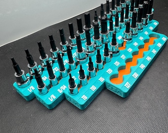 Könnte beinhalten: Eine Sammlung von Metall-Sechskant- und Torx-Steckschlüsseleinsätzen, angeordnet in drei türkisfarbenen Kunststoffhaltern mit orangefarbenen Einsätzen. Jeder Einsatz hat einen schwarzen Stahlbit und eine silberne Basis, mit Größenangaben wie 1/8, 9/64, T6, T10, T15, T20, T25, T27, T30, T40, T45, T50 und T55 auf der Kunststoffbasis.