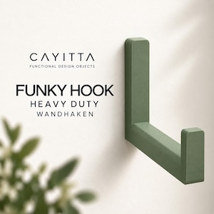 May include: A sage green L-shaped wall hook with a matte finish. The text CAYITTA FUNCTIONAL DESIGN OBJECTS FUNKY HOOK HEAVY DUTY WANDHAKEN is printed to the left of the hook. The hook has a vertical back plate and a horizontal arm with an upward tip.