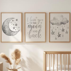 May include: Three framed nursery art prints. The first features a watercolour crescent moon and stars. The second says "I love you to the moon and back." The third shows a cloud with hanging stars. The frames are light wood.