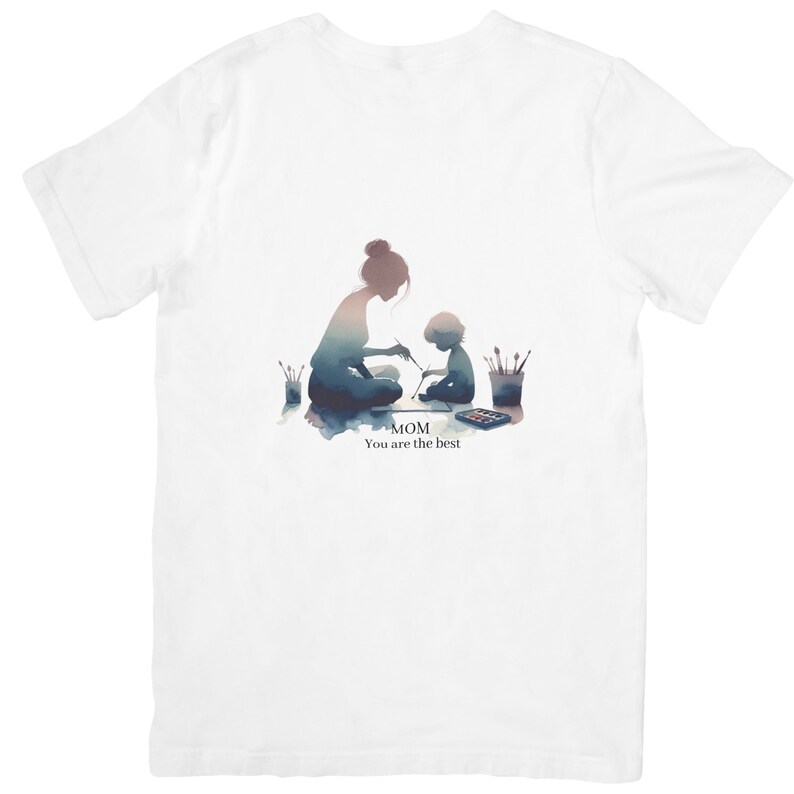 Op de afbeelding: Een wit T-shirt met een aquarel-illustratie van een moeder en kind die samen schilderen. De tekst "MOM You are the best" staat onder de afbeelding.