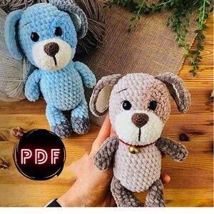 May include: Two handmade crochet dog stuffed animals. One is light blue with gray accents, the other is tan and brown. The tan dog has a red collar with a small gold bell. The image includes a PDF icon.