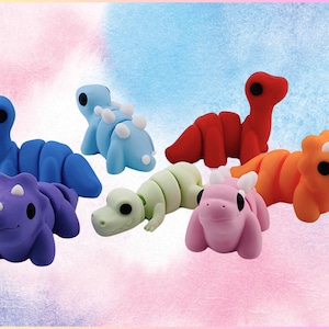 May include: A set of seven colourful dinosaur-shaped toys. The dinosaurs are made of a soft, pliable material and are perfect for imaginative play. The dinosaurs are blue, purple, green, orange, pink, and red.
