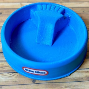 Puede incluir: Una piscina infantil de plástico azul con un tobogán, con el logotipo de Little Tikes.