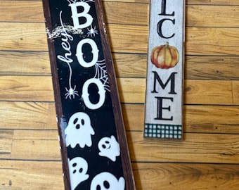 May include: Two wooden signs, one with the text "Hey Boo" and a black background with white ghosts, and the other with the text "Welcome" and a pumpkin graphic.