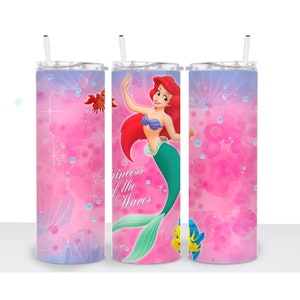 May include: Three pink stainless steel tumblers with a mermaid design. The center tumbler features Ariel, the Little Mermaid, with the text "Princess of the Waves".