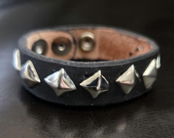 Black single-row pyramid stud leather bracelet.