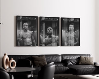 May include: Three framed black and white portraits of muscular men with tattoos. The portraits are displayed above a black leather sectional sofa. The room has a modern design with a black table and decorative vases.