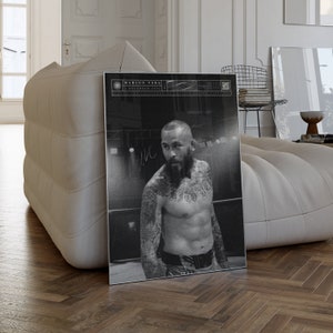 Puede incluir: Póster en blanco y negro de Marlon Vera, con tatuajes y barba. El texto "Marlon Vera" y "5 de diciembre de 2023" es visible. La imagen se presenta sobre un suelo de madera.