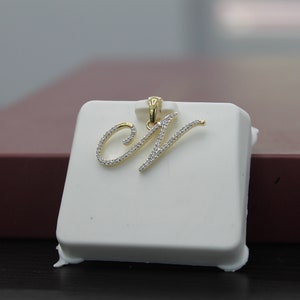 Colgante minimalista con iniciales cursivas del alfabeto N en oro natural y diamantes