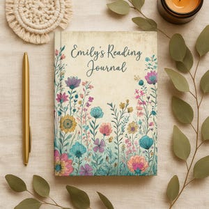 May include: A rectangular reading journal with a cream-colored cover featuring a vintage-style illustration of colorful wildflowers in shades of pink, blue, and yellow. The text 'Emily's Reading Journal' is printed in a dark blue cursive script.
