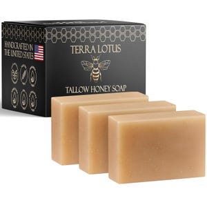 May include: Three rectangular bars of Tallow Honey Soap are displayed in front of a black box. The box features the brand name "Terra Lotus" with a bee illustration and the text "Tallow Honey Soap." The box also states "Handcrafted in the United States."