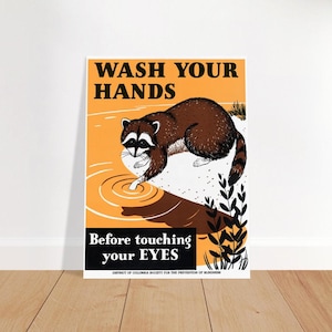 May include: A vintage-style poster with a yellow background and black text that reads "Wash Your Hands Before Touching Your Eyes". A cartoon raccoon is depicted drinking from a puddle of water. The poster is from the District of Columbia Society for the Prevention of Blindness.
