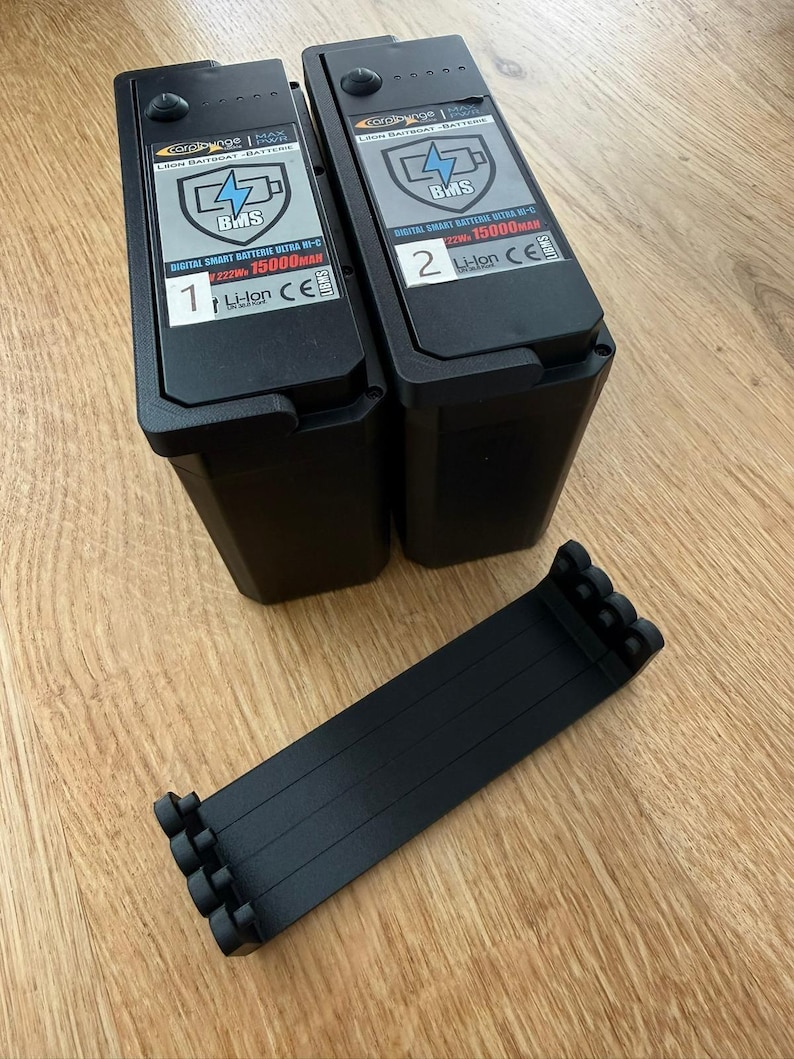Set of four black PETG-CF battery levers next to two Carplounge smart batteries