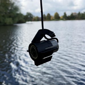 Stealthcam UK Winchcam camera in the black anti-spinner hanging on its cable above the lake, looking straight ahead