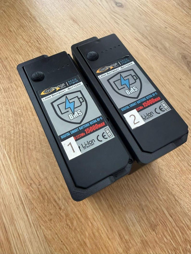 Two Carplounge RT4 RT7 smart batteries with the replacement levers folded down flat