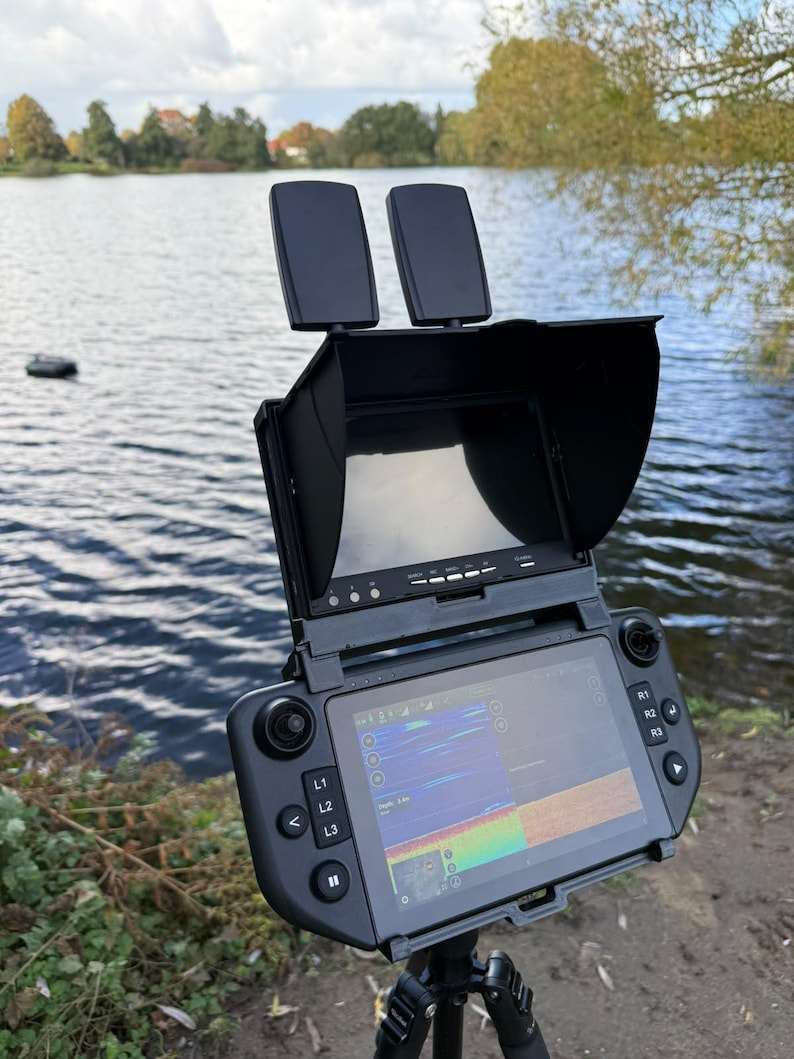 Carplounge AIO controller on a tripod at the lake with the 7 inch Winchcam underwater camera monitor mounted above the screen in the black 3D printed holder, bait boat on the water